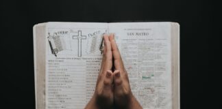 Złożone dłonie na otwartej Biblii, modlitwa w chwilach lęku