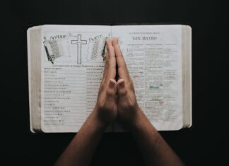 Psalmy w chwilach lęku i niepokoju – modlitwa, która przywraca sercu pokój Złożone dłonie na otwartej Biblii, modlitwa w chwilach lęku